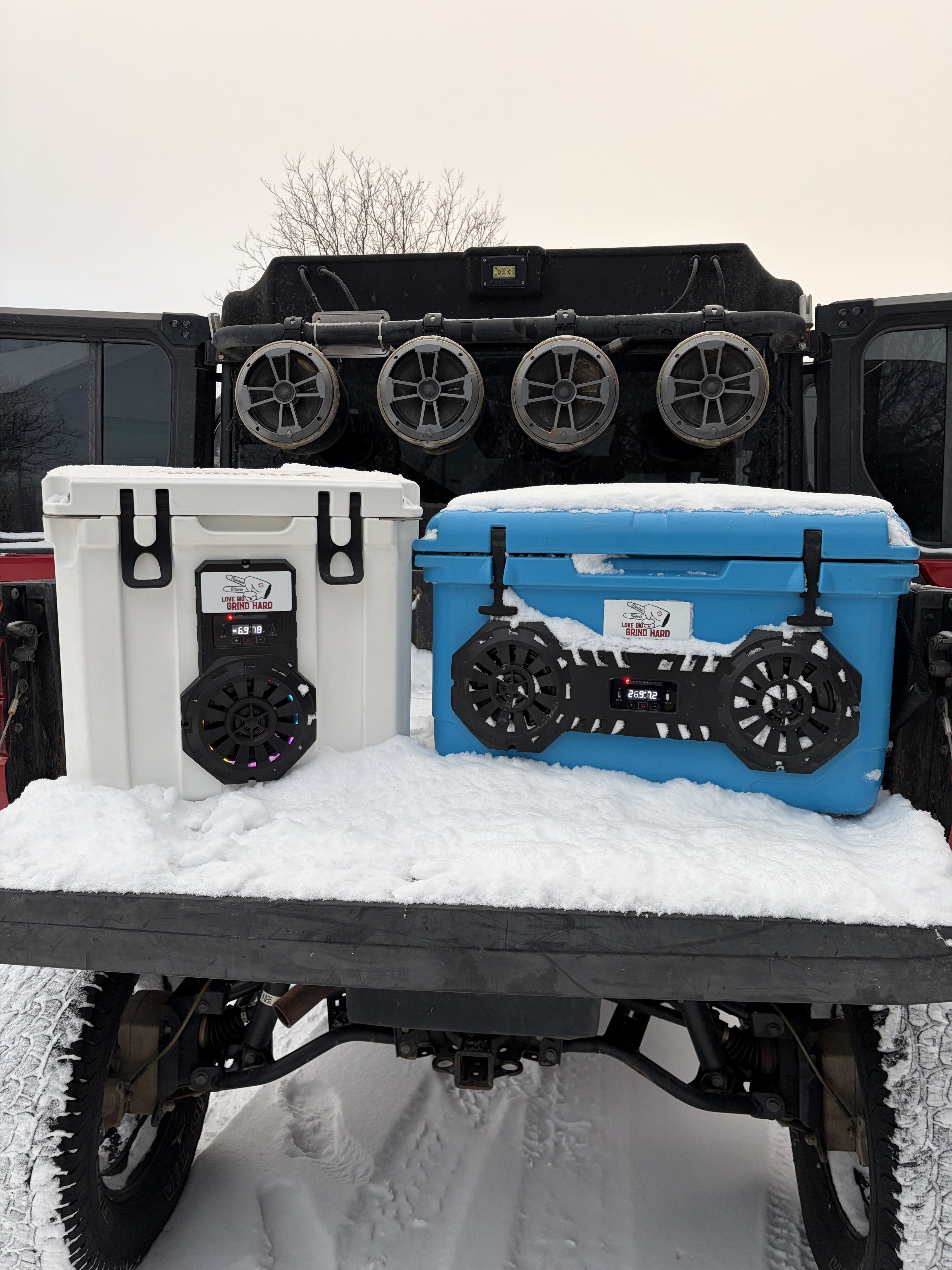 Hound Boxx Bluetooth cooler speakers on truck tailgate in snowy outdoor adventure setting with white and blue cooler speaker systems for camping, tailgating, and lifestyle use