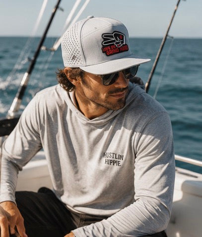 Man wearing gray Love Big Grind Hard hydro snapback hat on a boat with ocean adventure lifestyle aesthetic