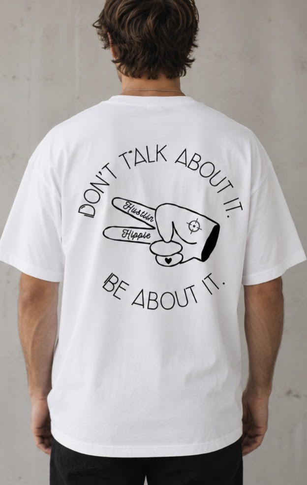Back view of white Hustlin Hippie ‘BE ABOUT IT’ t-shirt with large black graphic and slogan design
