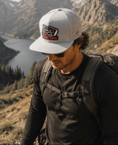 Outdoor hiking lifestyle photo featuring gray Love Big Grind Hard hydro snapback hat in mountain landscape