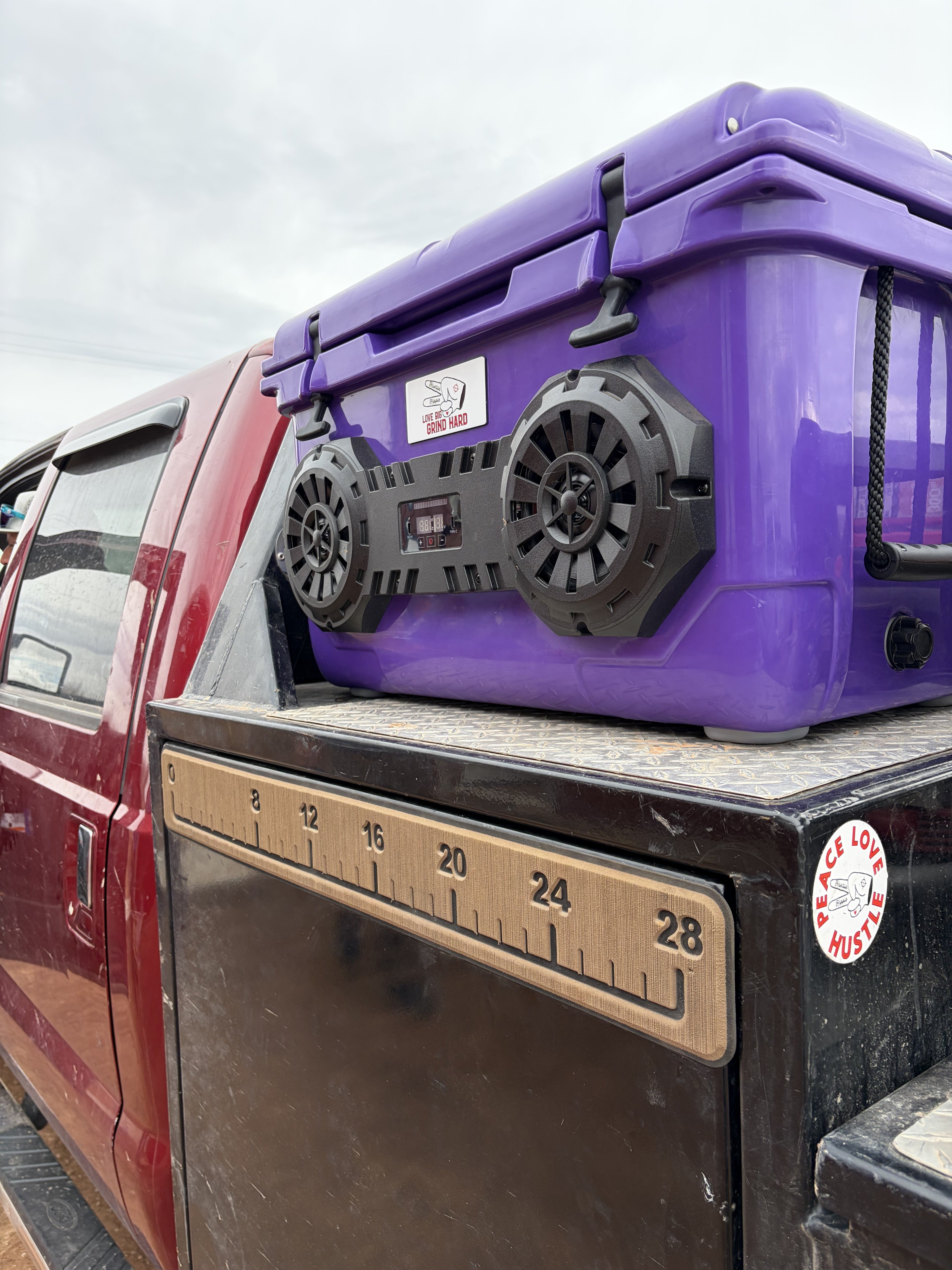 Purple dual speaker Hound Boxx Bluetooth cooler in truck bed ready for the jobsite