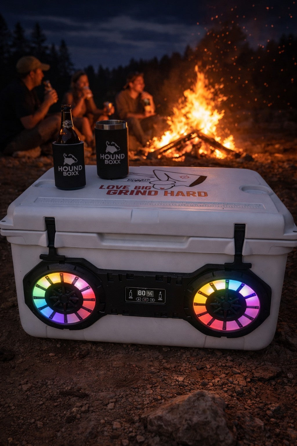 White Dual Hound Boxx Bluetooth cooler with RBG lights beside campfire at night.