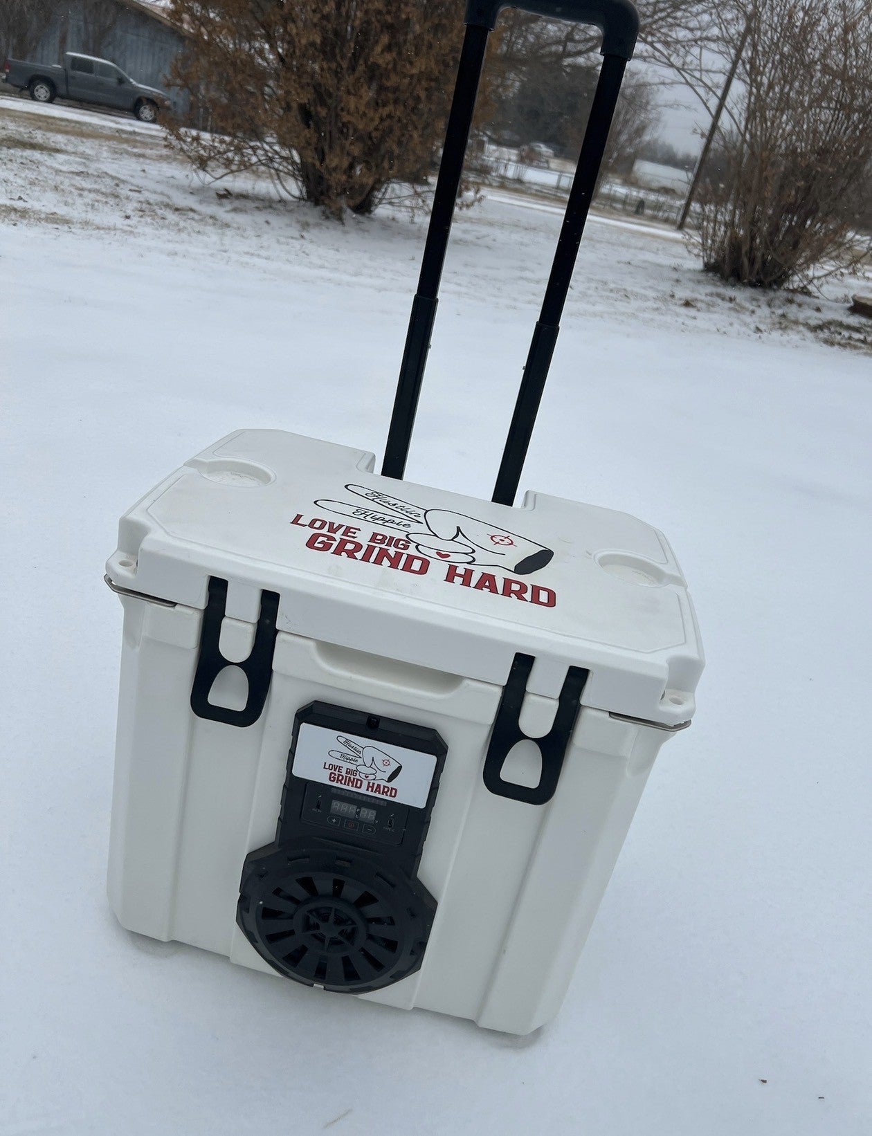 White Mono Hound Boxx cooler speaker with pull handle standing in snow outdoors