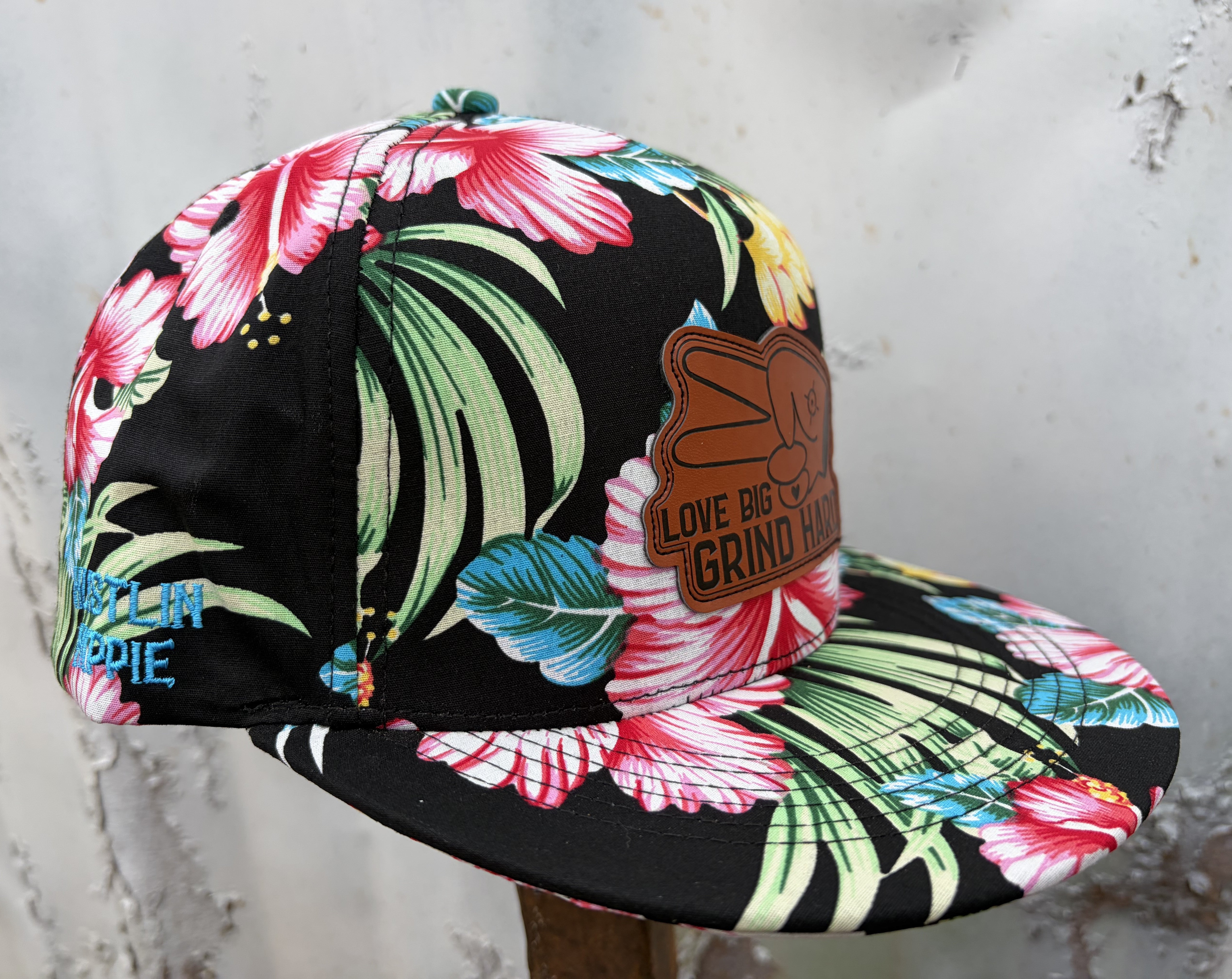 Side angle of Love Big Grind Hard tropical floral snapback hat with colorful hibiscus print and leather patch.
