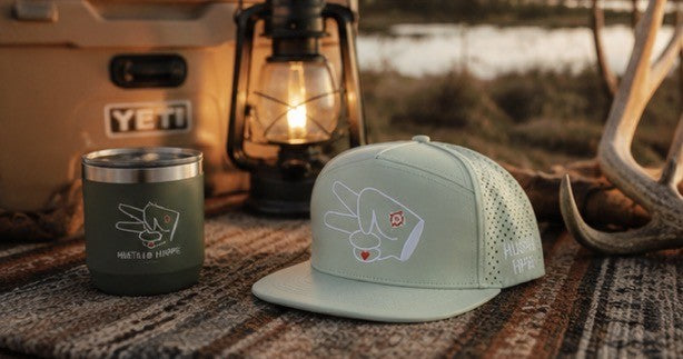 Signature Mint Green Hydro Snapback Hat styled beside camping gear and lantern for cozy outdoor adventure vibes.