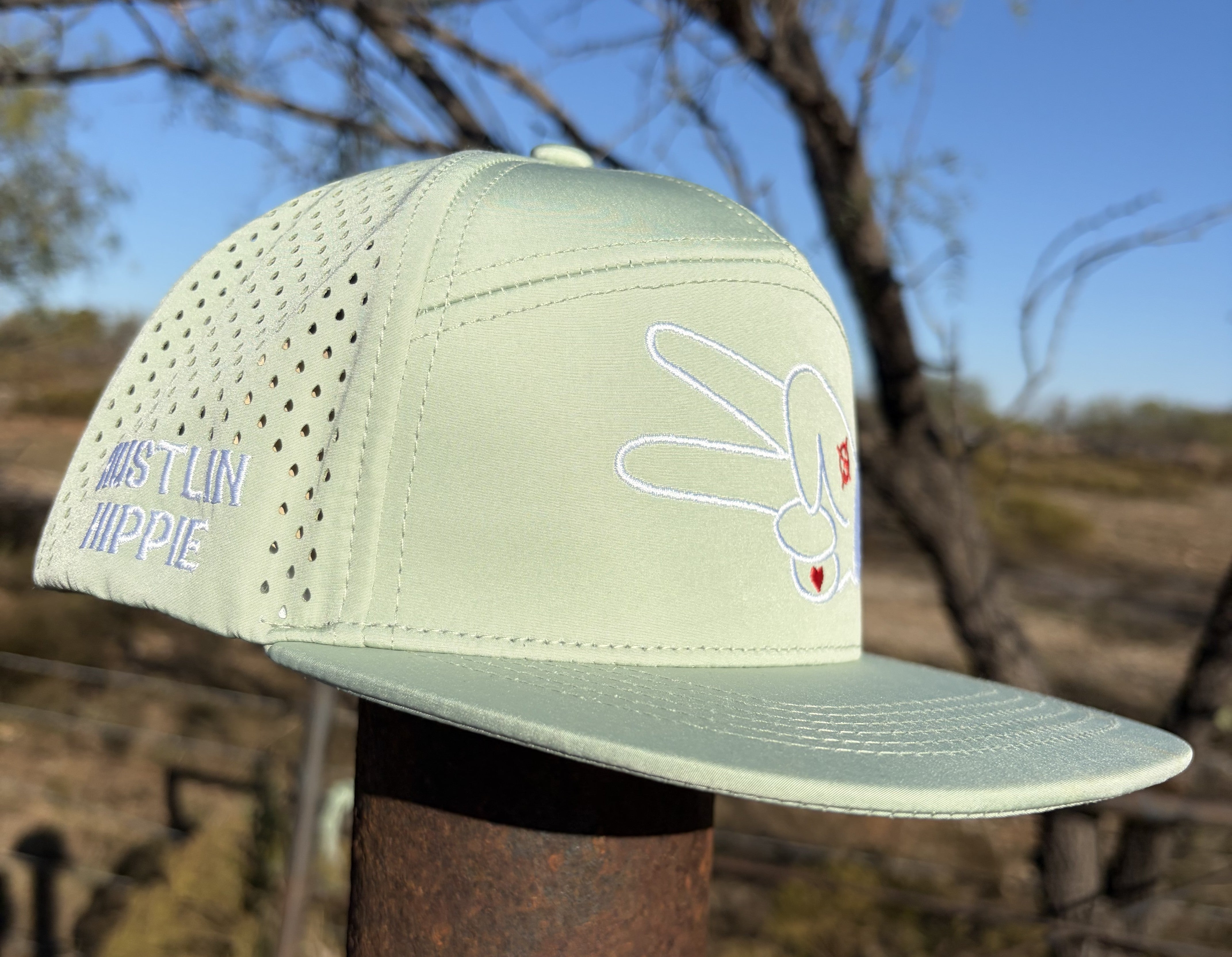 Mint green seven panel hydro snapback hat featuring the Hustlin Hippie signature peace hand logo and flat bill design.